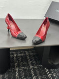 Pair of glossy burgundy-red Chanel high-heel pumps with black cap toes and sculptural slim heels