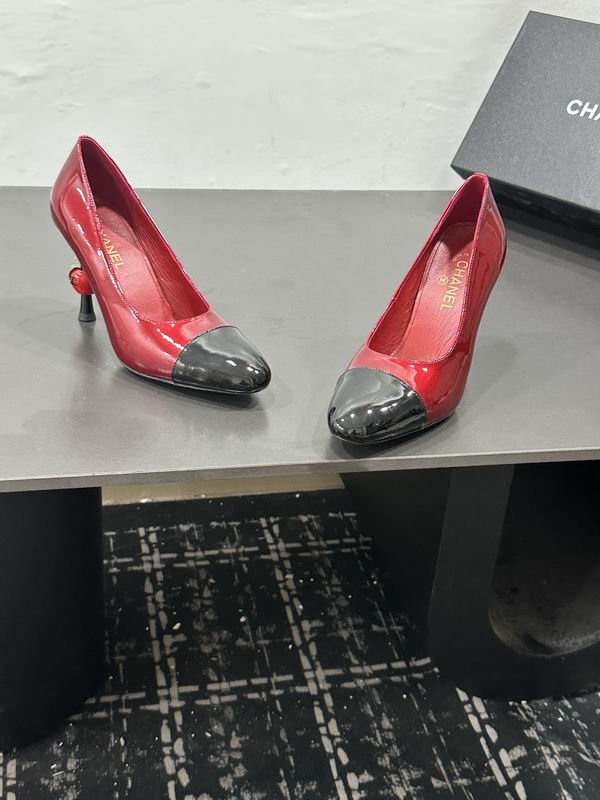 Pair of glossy burgundy-red Chanel high-heel pumps with black cap toes and sculptural slim heels